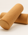 Due foam roller in sughero naturale Fitnexfly incrociati su sfondo bianco, accessori ideali per stretching, yoga e rilascio muscolare.