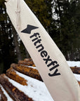 Sacca in cotone naturale con logo Fitnexfly in primo piano, progettata per trasportare il tappetino da yoga in sughero, perfetto per lo snowga e altre pratiche yoga all’aperto.