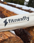 Tappetino Fitnexfly, ideale per yoga outdoor invernale, mostrato in un contesto naturale con tronchi innevati. Scelta ecologica per gli appassionati di yoga e natura.